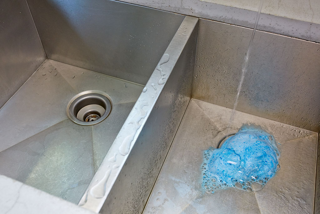 Glisten Garbage Disposal Cleaner foaming blue out of kitchen double sink